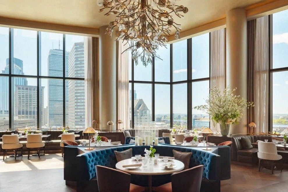 Sky-floor restaurant with chandelier and Boston skyline views at Raffles Boston