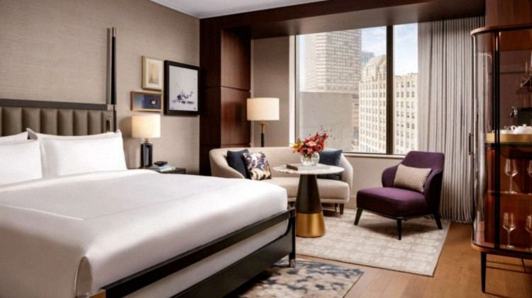 King guest room with skyline view and warm wood detailing at Raffles Boston